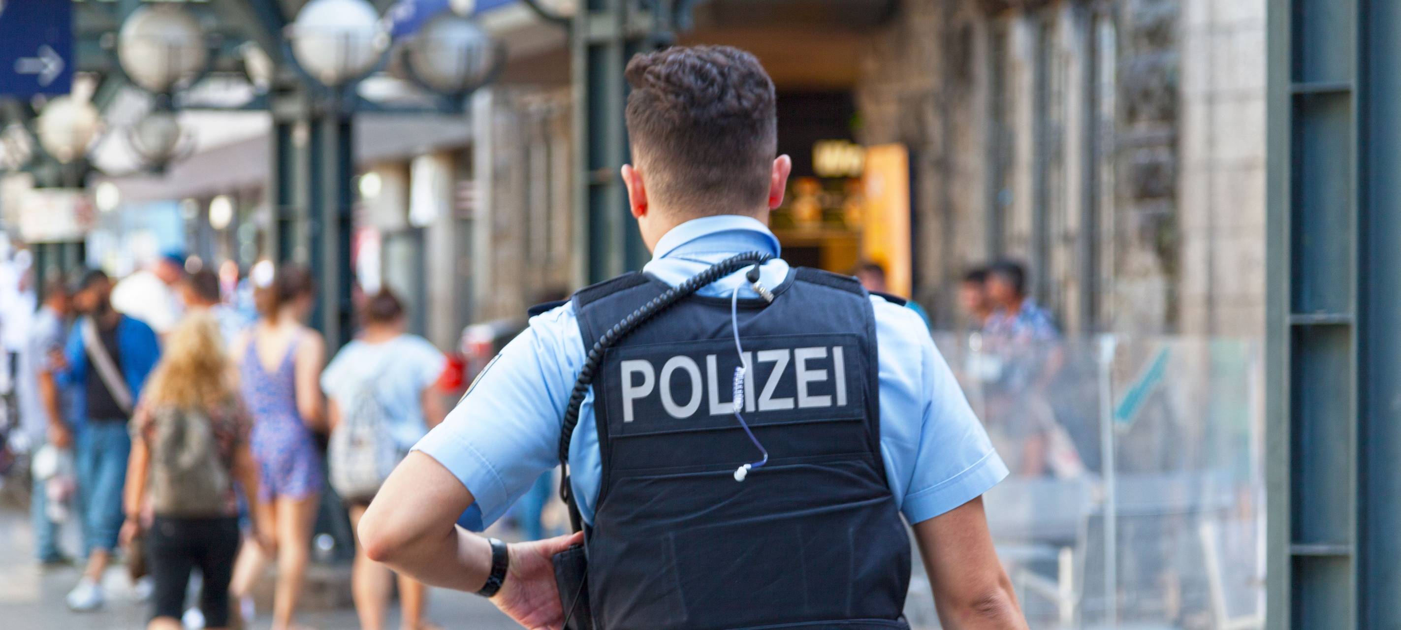 Mann mit Polizeiweste von hinten
