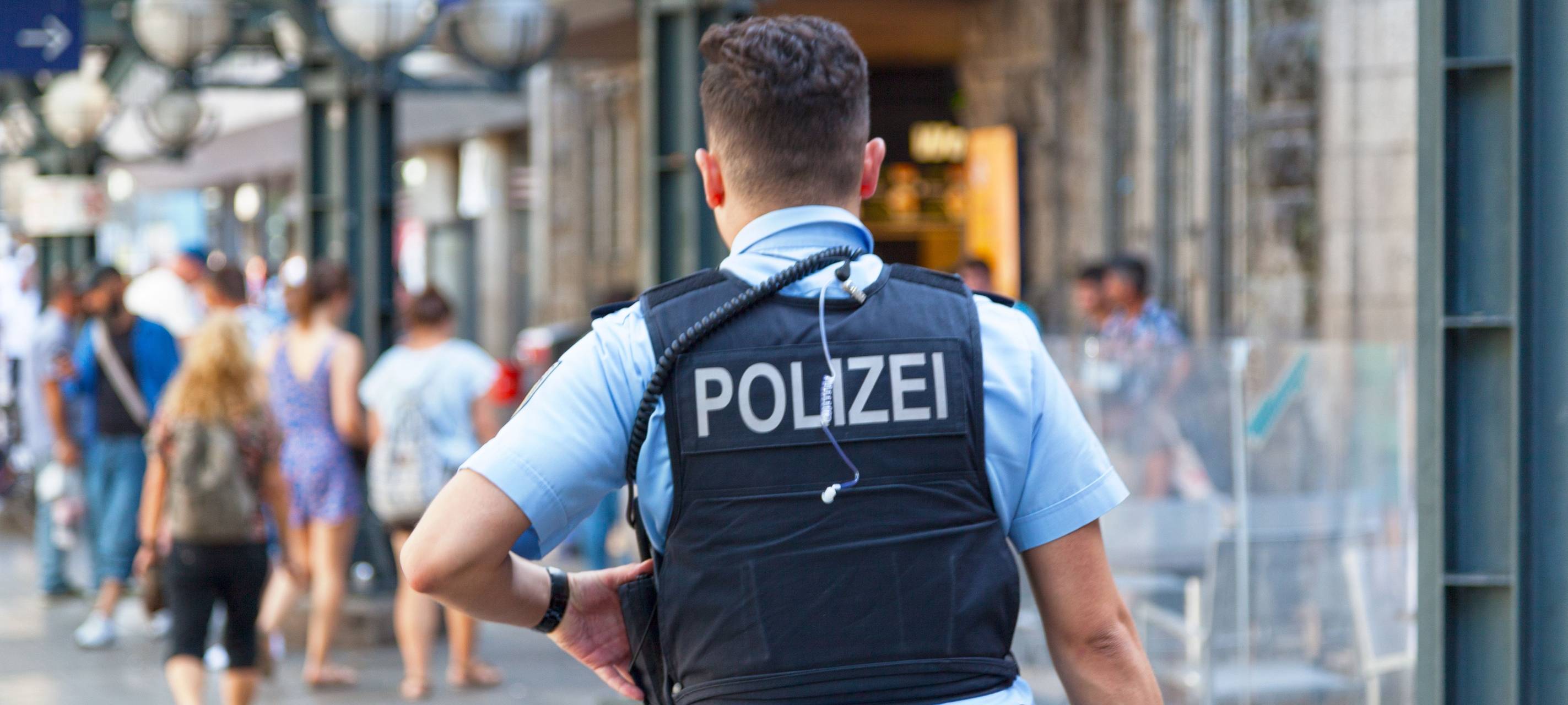 Polizist mit Weste von hinten