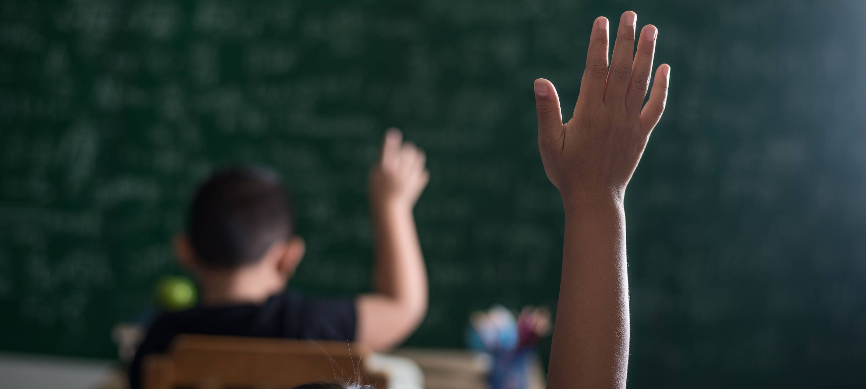 Kinder melden sich im Klassenzimmer
