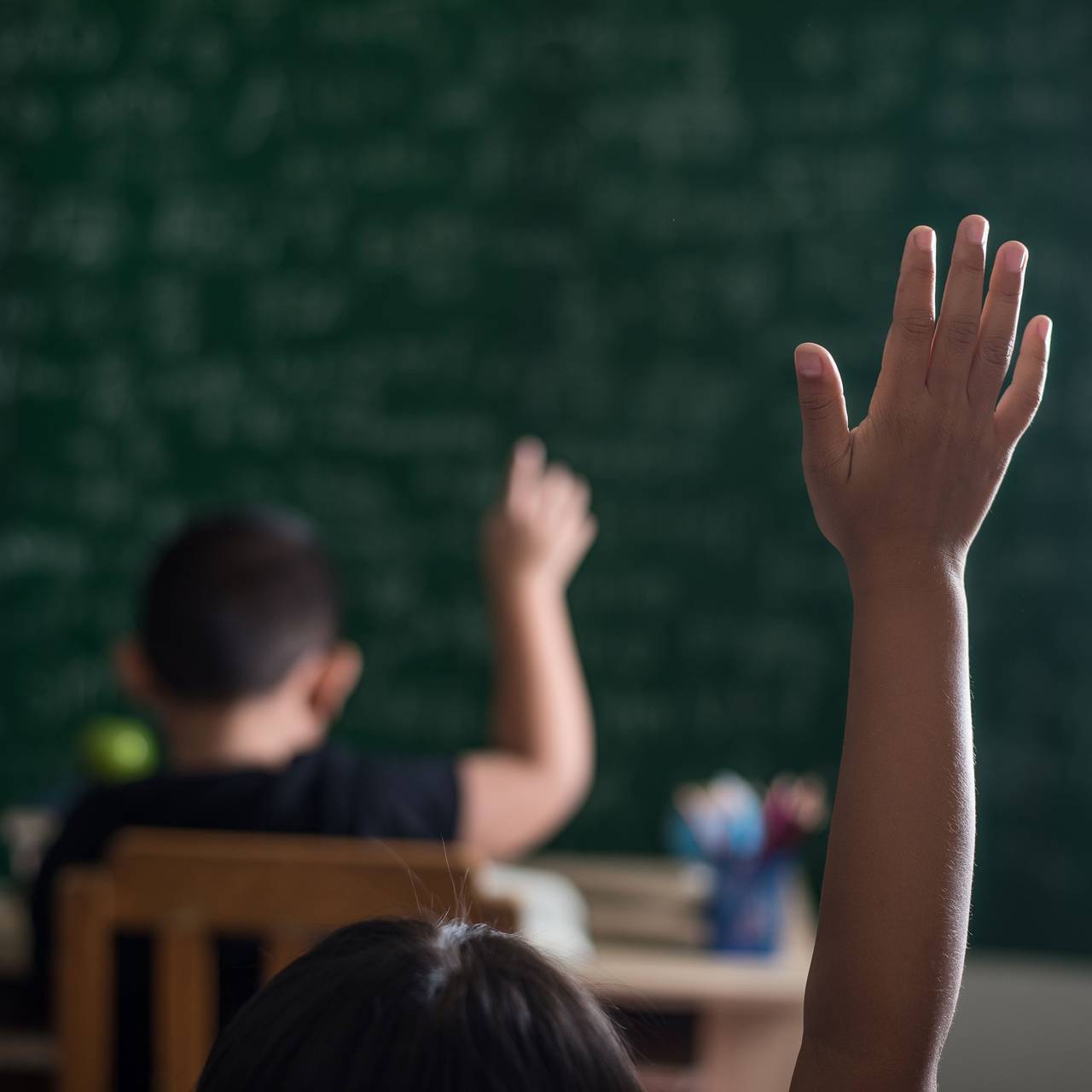 Kinder melden sich im Klassenzimmer