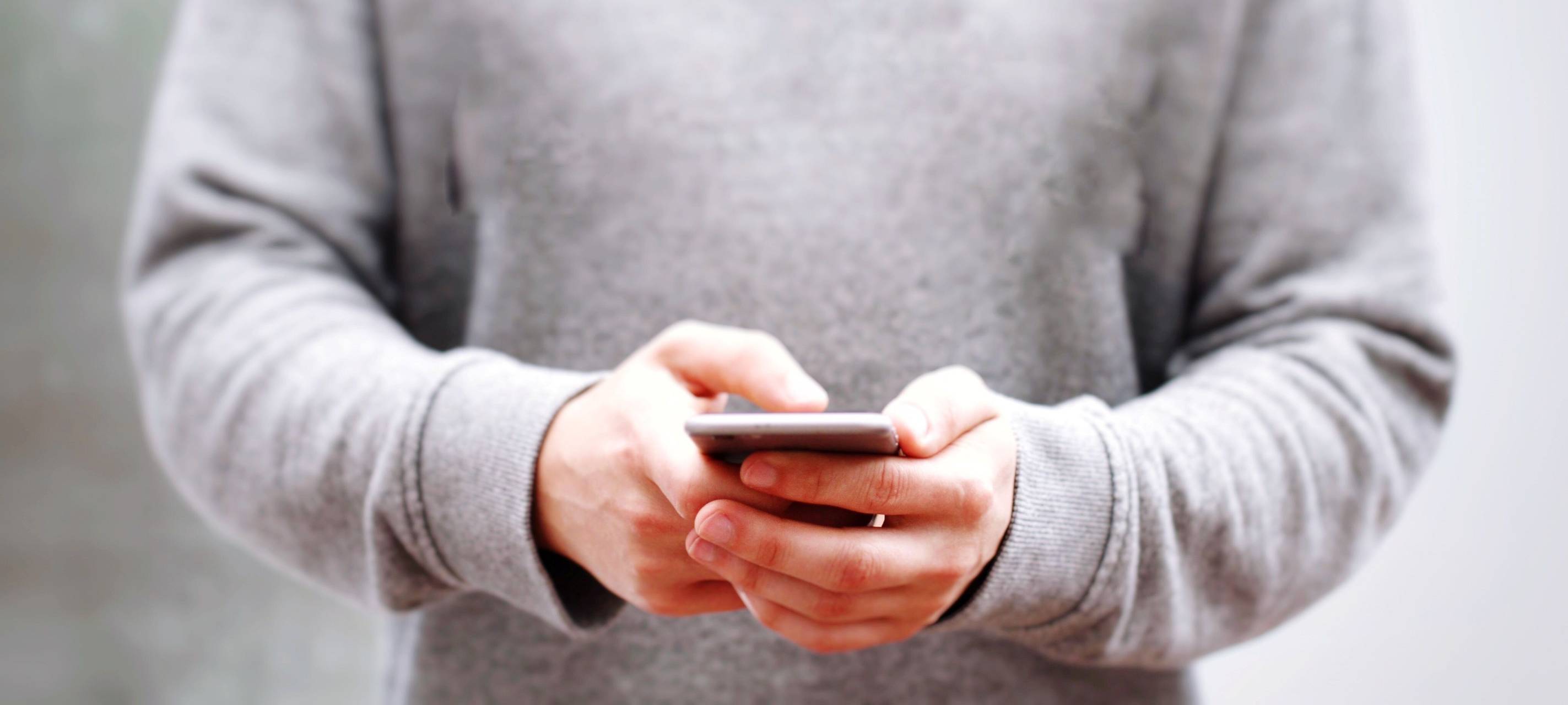 Eine Person hält ein Smartphone in der Hand