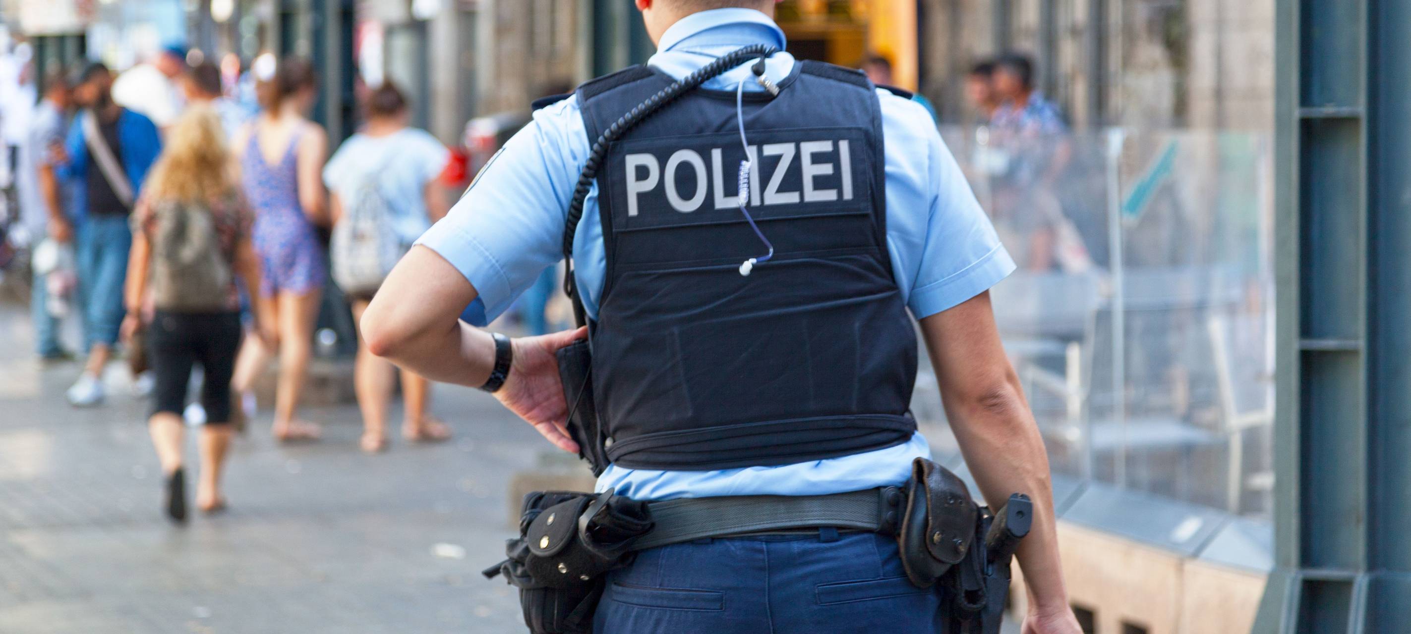 Polizist mit Weste von Hinten