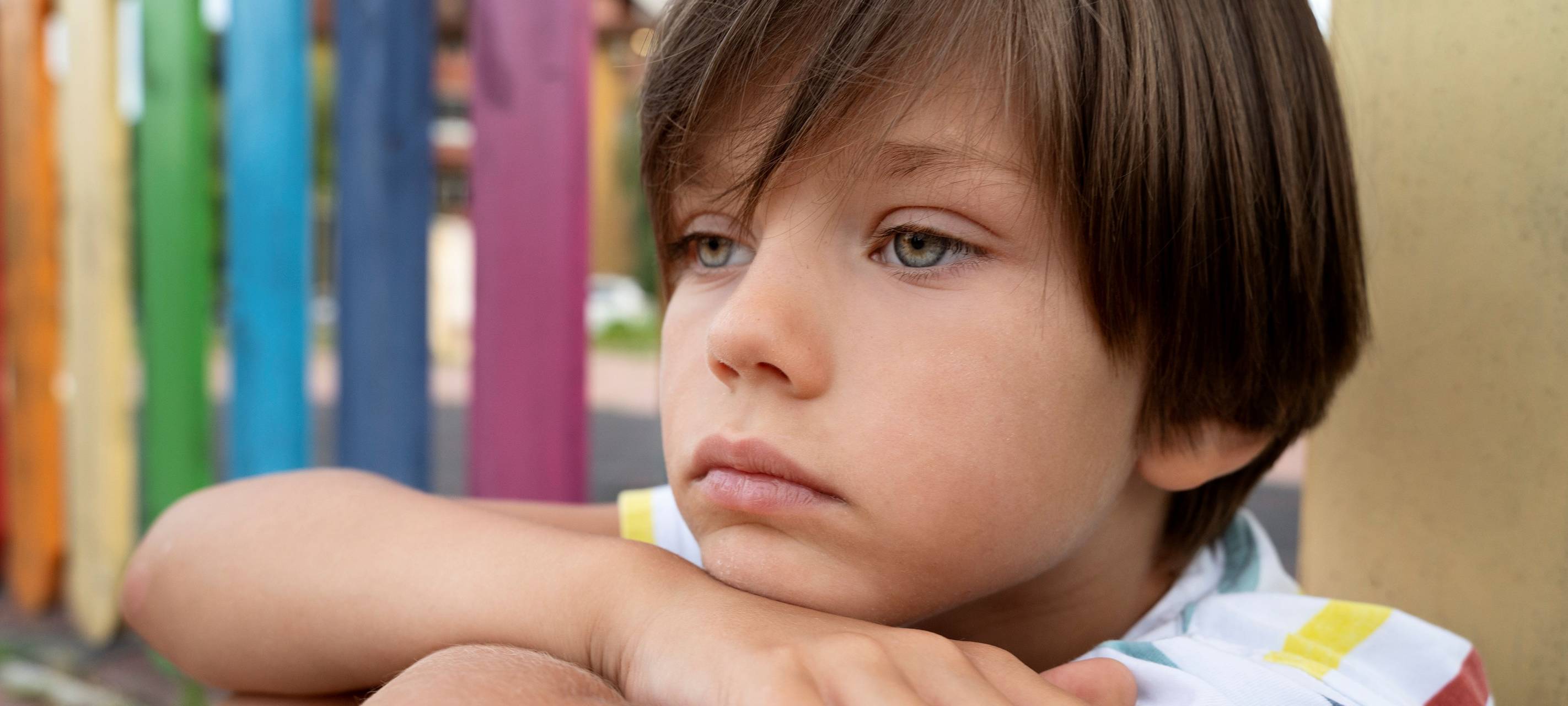 Kind sitzt traurig am Boden