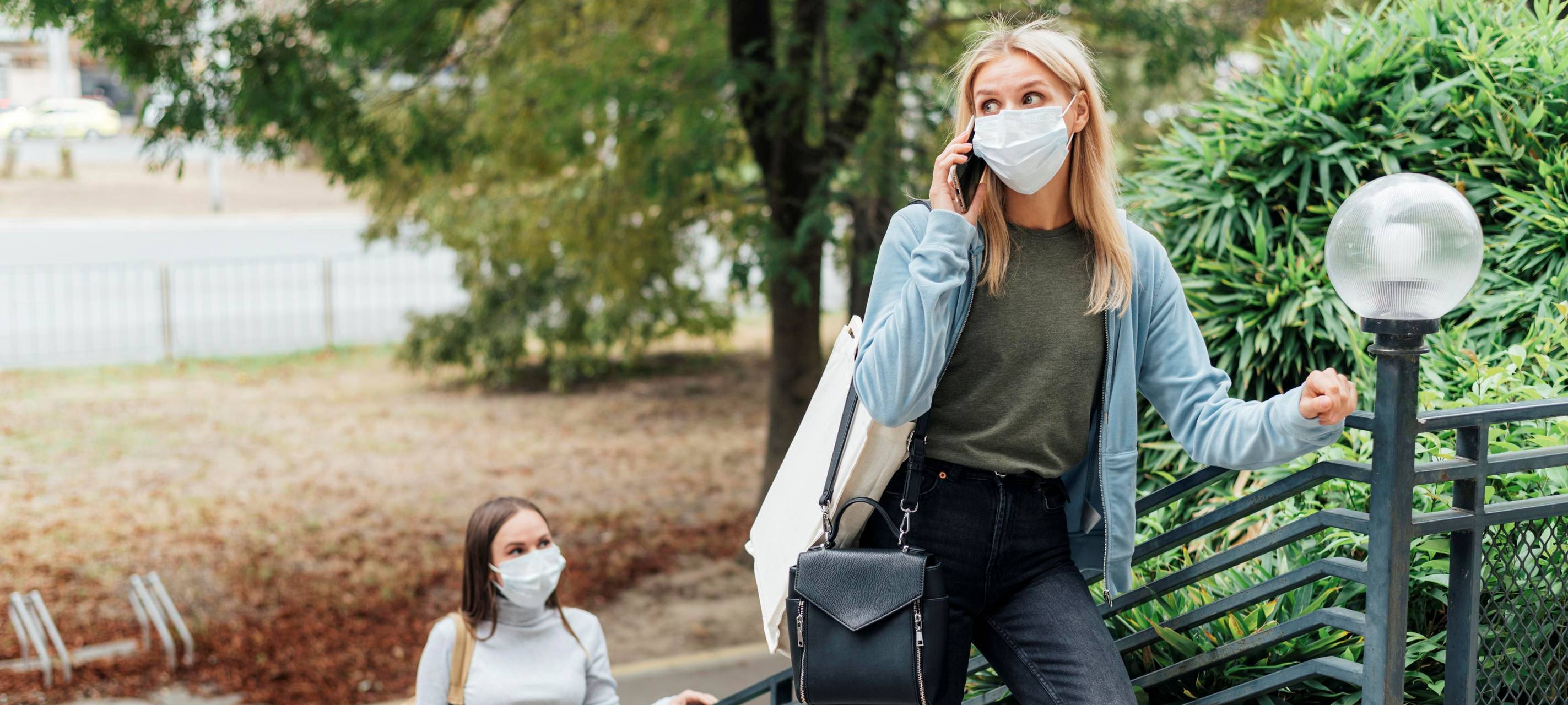 Zwei Frauen im Park tragen eine Maske