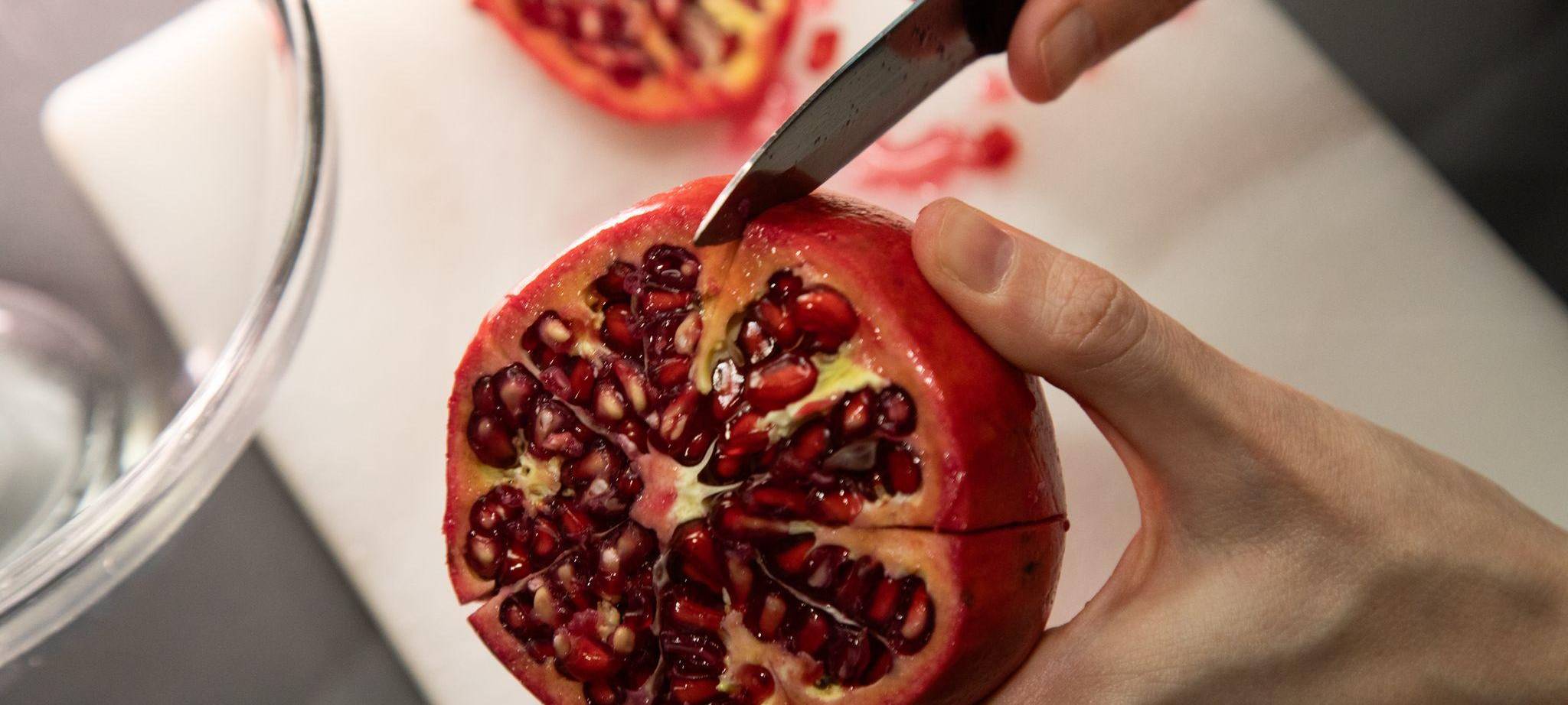 Granatapfel wird entlang der Kammern eingeschnitten