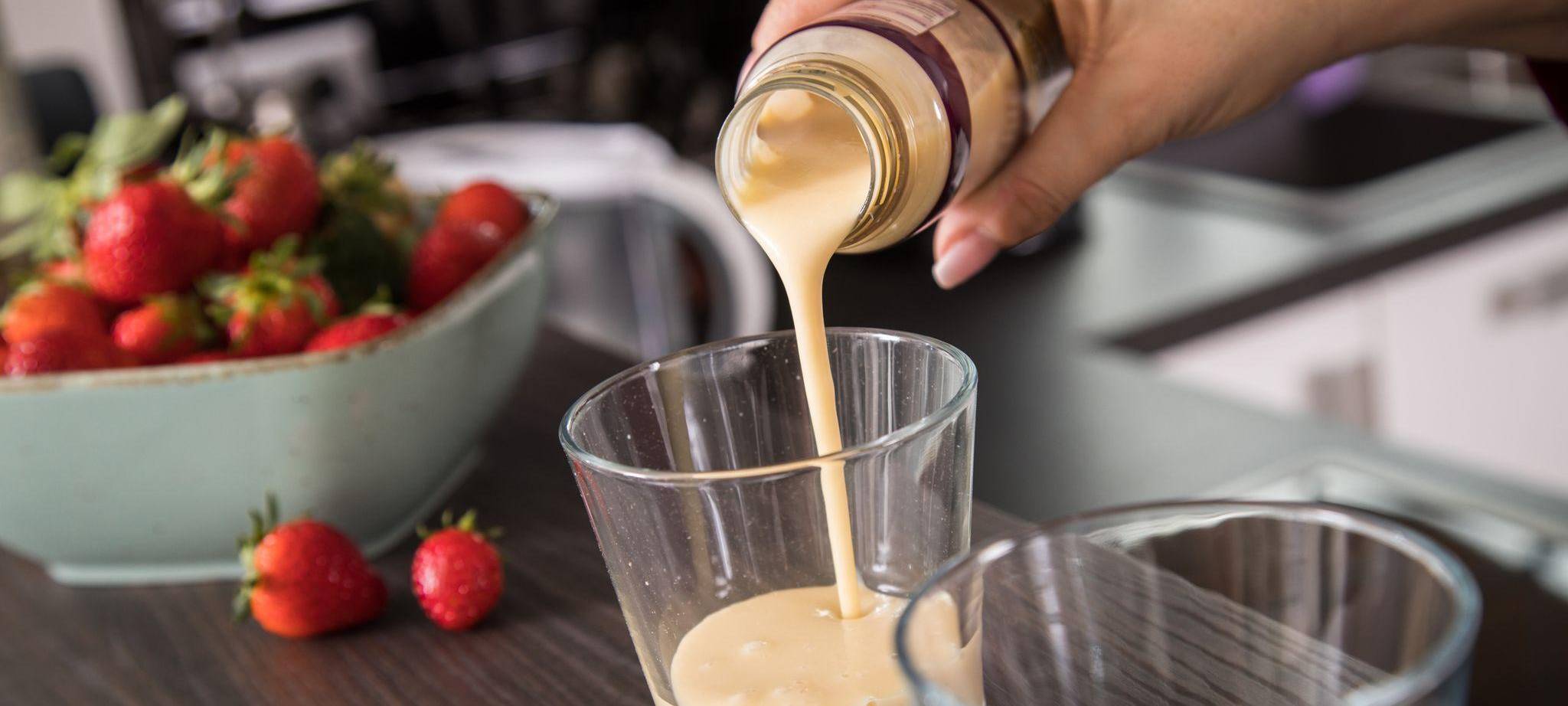 Eine Frau gießt ein Fertig-Getränk in ein Glas