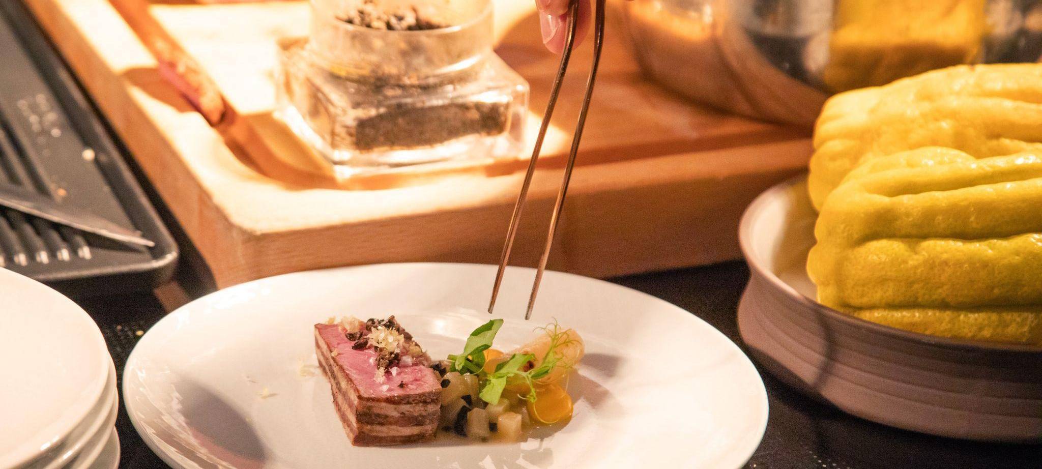 Ein Koch richtet sein Gericht auf einem Teller an