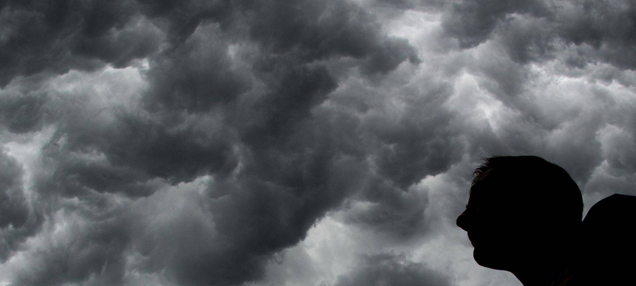 Ein Mann steht unter einem stürmischen Himmel