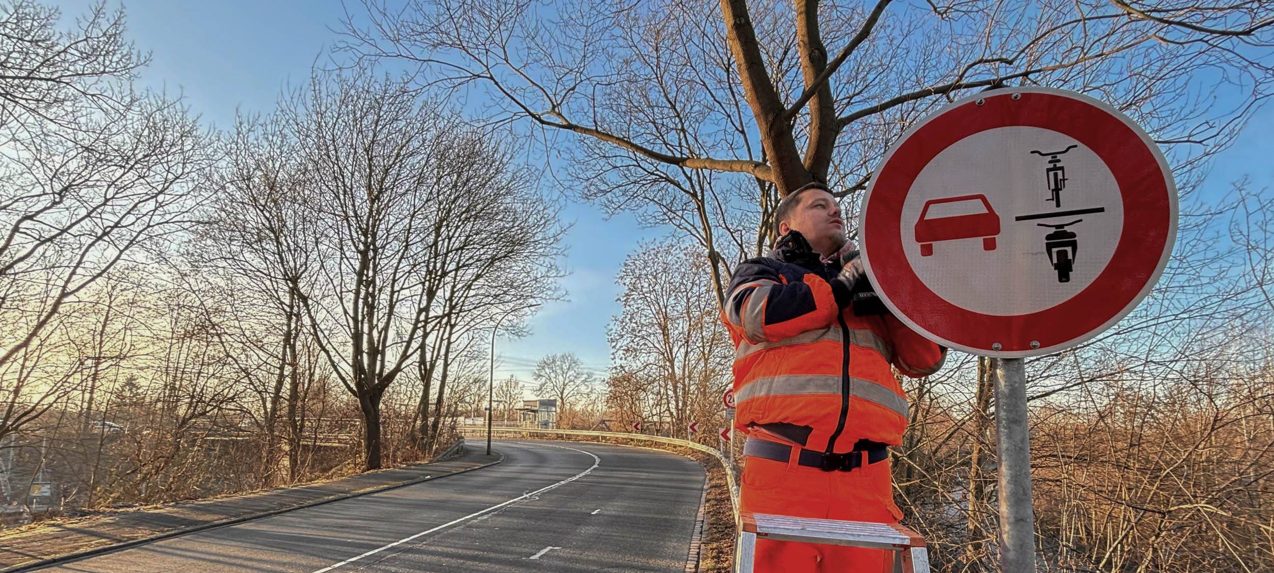 Stadt Dortmund-Mitarbeiter hängt neues verkehrsschild auf
