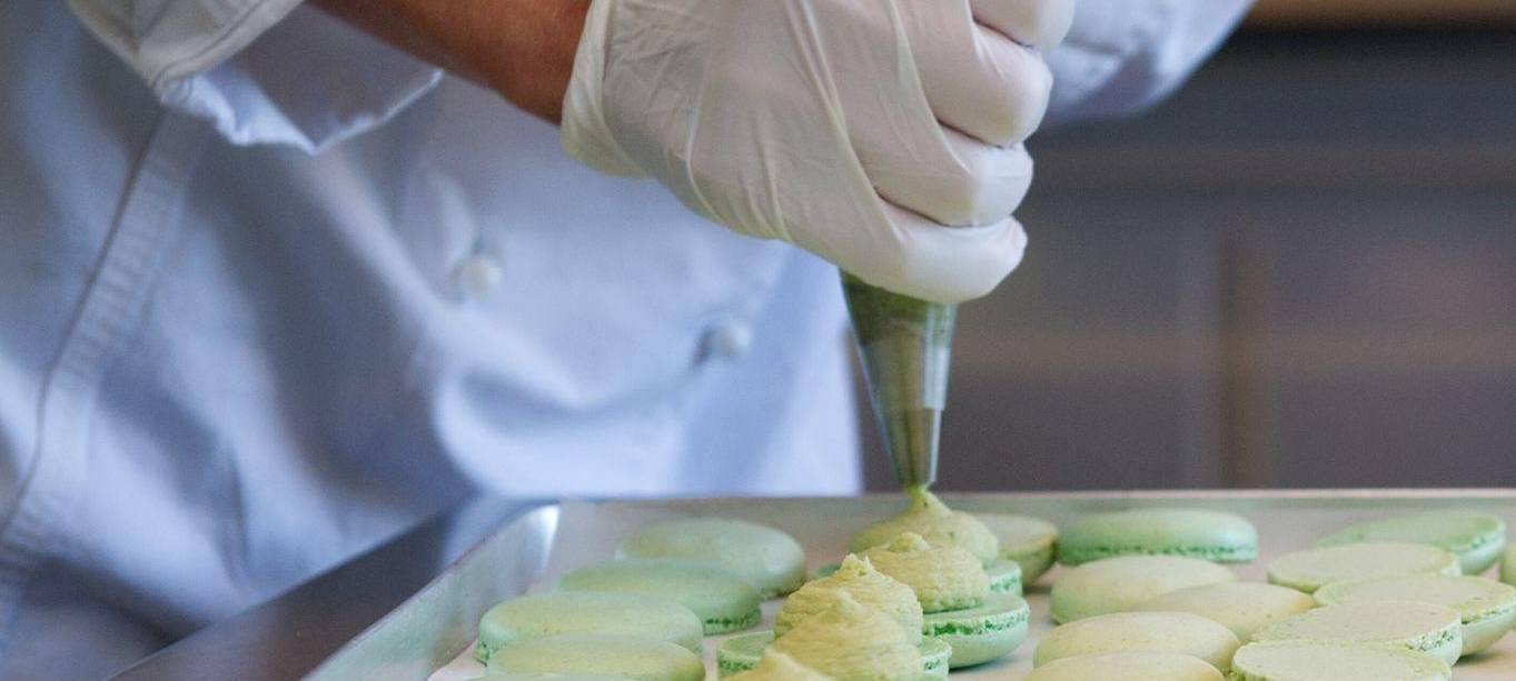 Macaronhälften werden mit einem Spritzbeutel gefüllt