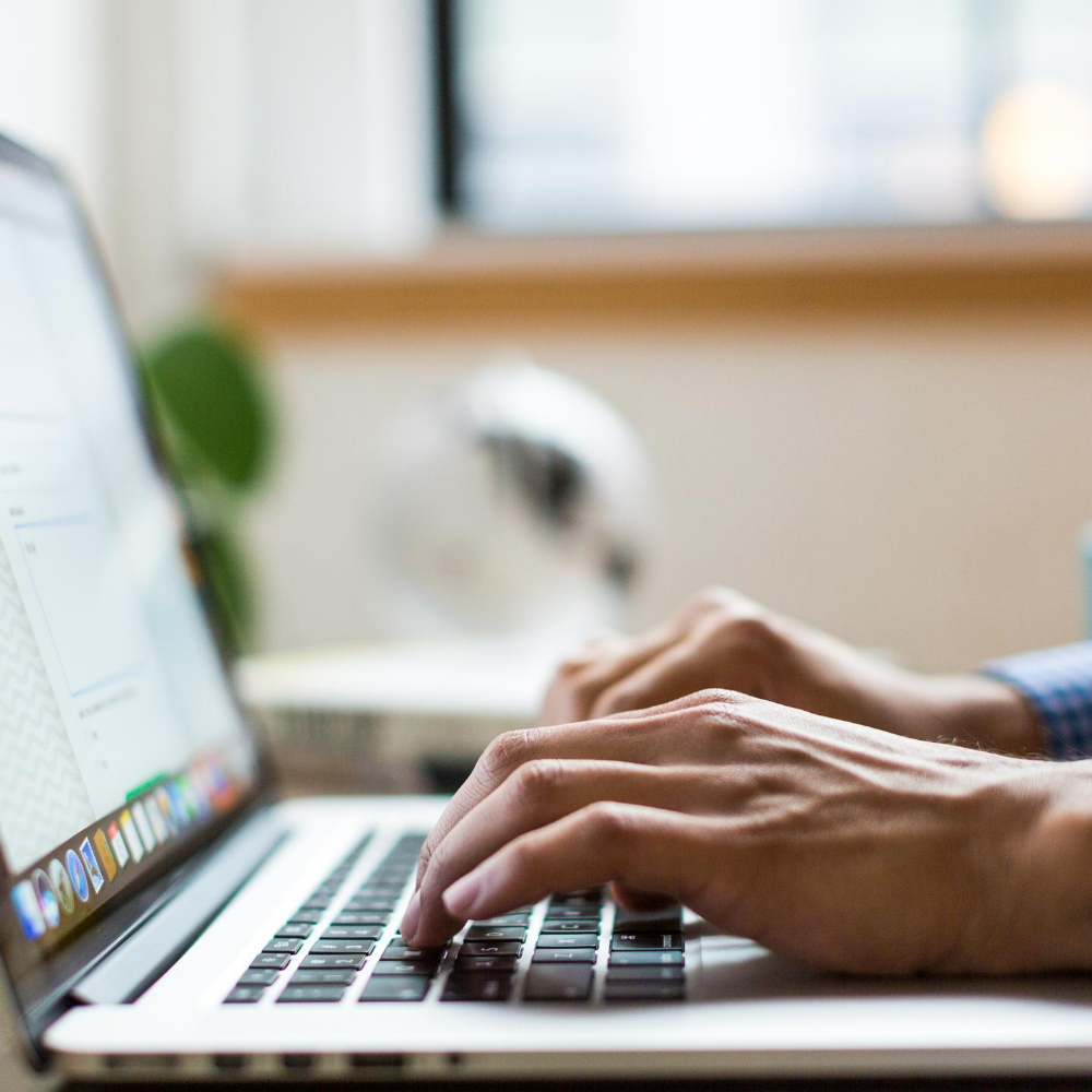 Mann schreibt am Laptop. Symbolbild.